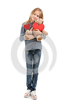 Cute little girl with red heart and teddy bear on white background