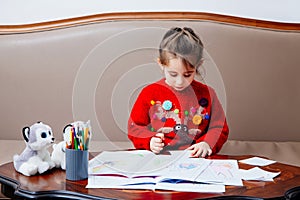 New year christmas pensil little girl writes letter Santa red jacket toy pen kid table sofa