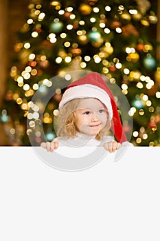 Cute little girl with red santa hat holding white board with space for text