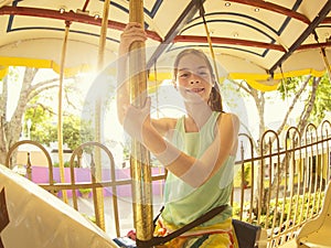 Cute little girl riding on a Carnival Carousel