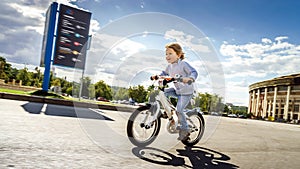 Cute little girl riding fast by bicycle