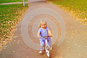 Cute little girl riding runbike in autumn, kids sport