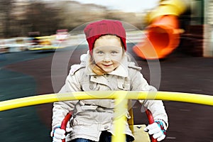 Cute little girl rounding on merry-go-round