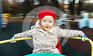 Cute little girl rounding on merry-go-round