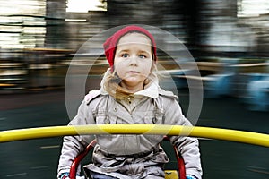 Cute little girl rounding on merry-go-round