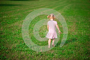 Cute little girl running at grass meadow