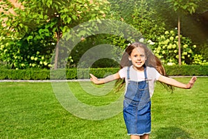 Cute little girl running in green park on summer