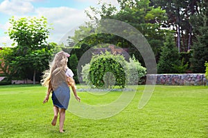 Cute little girl running in green park on summer