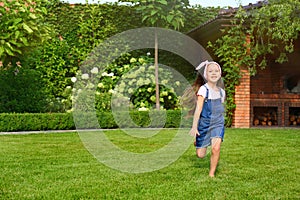 Cute little girl running in green park on summer