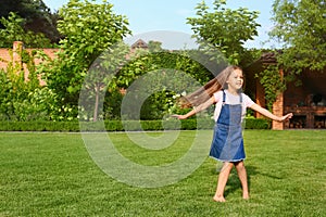 Cute little girl running in green park on summer