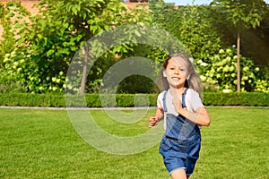 Cute little girl running in park on summer day