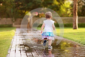 Cute little girl running through puddles