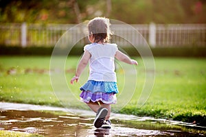 Cute little girl running through puddles