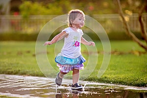 Cute little girl runnung through puddles photo