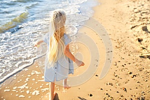 Cute little girl running on sea beach