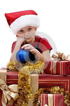 Cute little girl in a Santa Claus cap with Christmas gifts, isolated