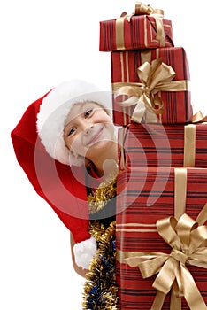 Cute little girl in a Santa Claus cap with Christmas gifts, isolated