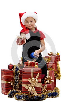 Cute little girl in a Santa Claus cap with Christmas gifts, isolated