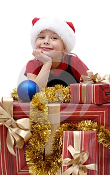 Cute little girl in a Santa Claus cap with Christmas gifts, isol