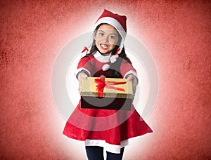 Cute Little Girl in Santa Claus costume holding a Christmas Box