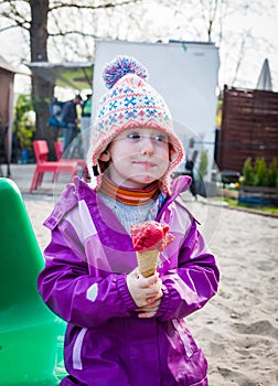 Cute little girl savour her ice cream in winter