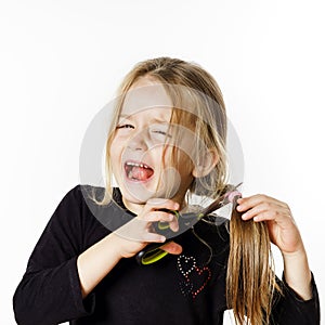 Cute little girl with scissors. Self hairdresser