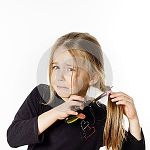 Cute little girl with scissors. Self hairdresser