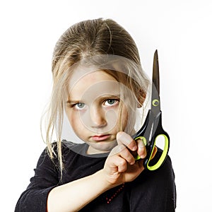 Cute little girl with scissors. Self hairdresser