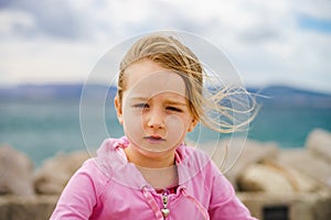 Cute little girl with ship anchor on the seaside