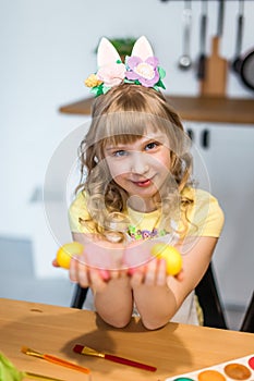 Cute little girl show painted  Easter eggs at her hands