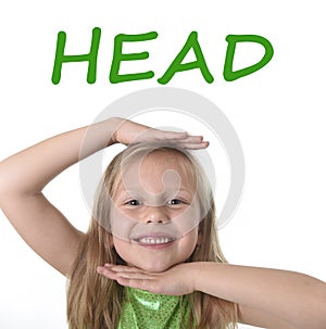 Cute little girl showing head in body parts learning English words at school