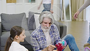 Cute Little Girl Showing Her New Dollhouse To Grandpa