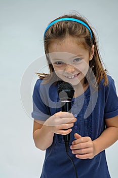 Cute little girl sings a karaoke song with microphone