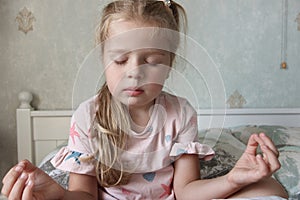 Cute little girl sitting on the bed and relaxing. Concept of health care