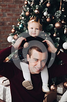 Cute little girl sitting on father`s neck.