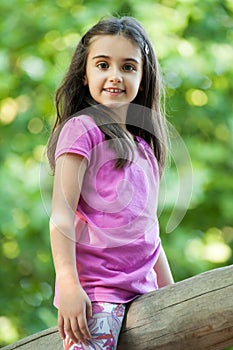 Cute little girl straddling a wooden pole photo