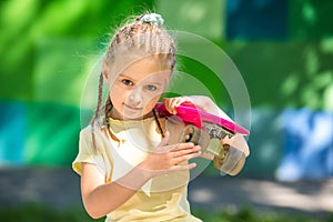 Cute little girl with a skateboard on her shoulder