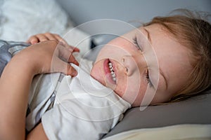 Cute little girl sleeping and grinding teeth in dreams, clenched teeth with tiredness and stress