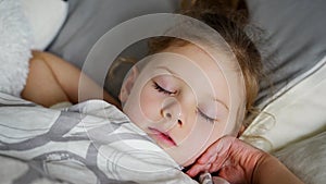 Cute little girl sleeping and grinding teeth in dreams, clenched teeth with tiredness and stress