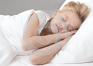 Cute little girl sleeping on a white pillow