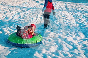 Cute little girl slide in winter snow, family have fun outside