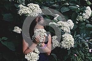 Cute little girl smelling lilac