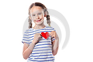 Cute little girl smiling and holding red decorative heart isolated on white background