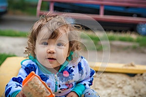 Cute little girl smiling playing in the sandbox
