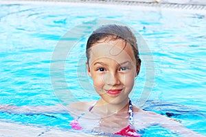 Cute little girl is smiling in swimming pool. Summer, vacation,