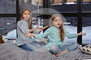 The cute little girl is snitching at her sister, pointing at her with her finger