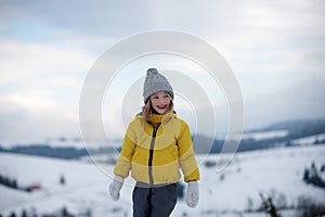 Cute little girl on snow winter nature. Funny kid in winter clothes. Children play outdoors in snow. Kids Christmas