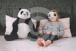 Cute little girl with soft big plush panda at home. Concept of family, healthy sleep of child, upbringing, parenting. Ð¡hildhood