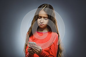 Cute little girl speaking on the cell phone. isolated on gray