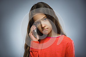 Cute little girl speaking on the cell phone. isolated on gray